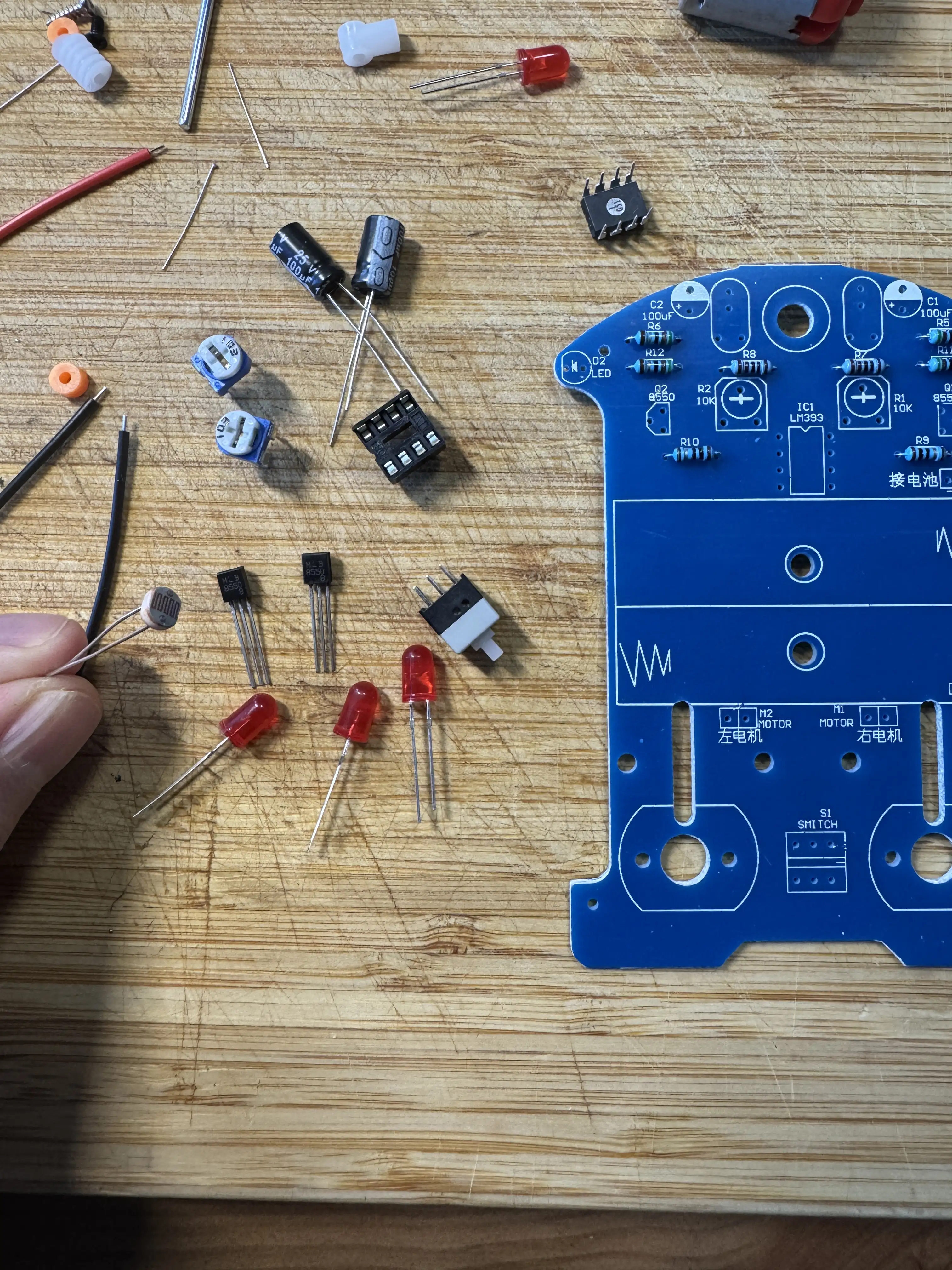 Componente neasamblate — capacitori electrolitici, LED-uri roșii, IC-ul în soclu, rezistențe colorate