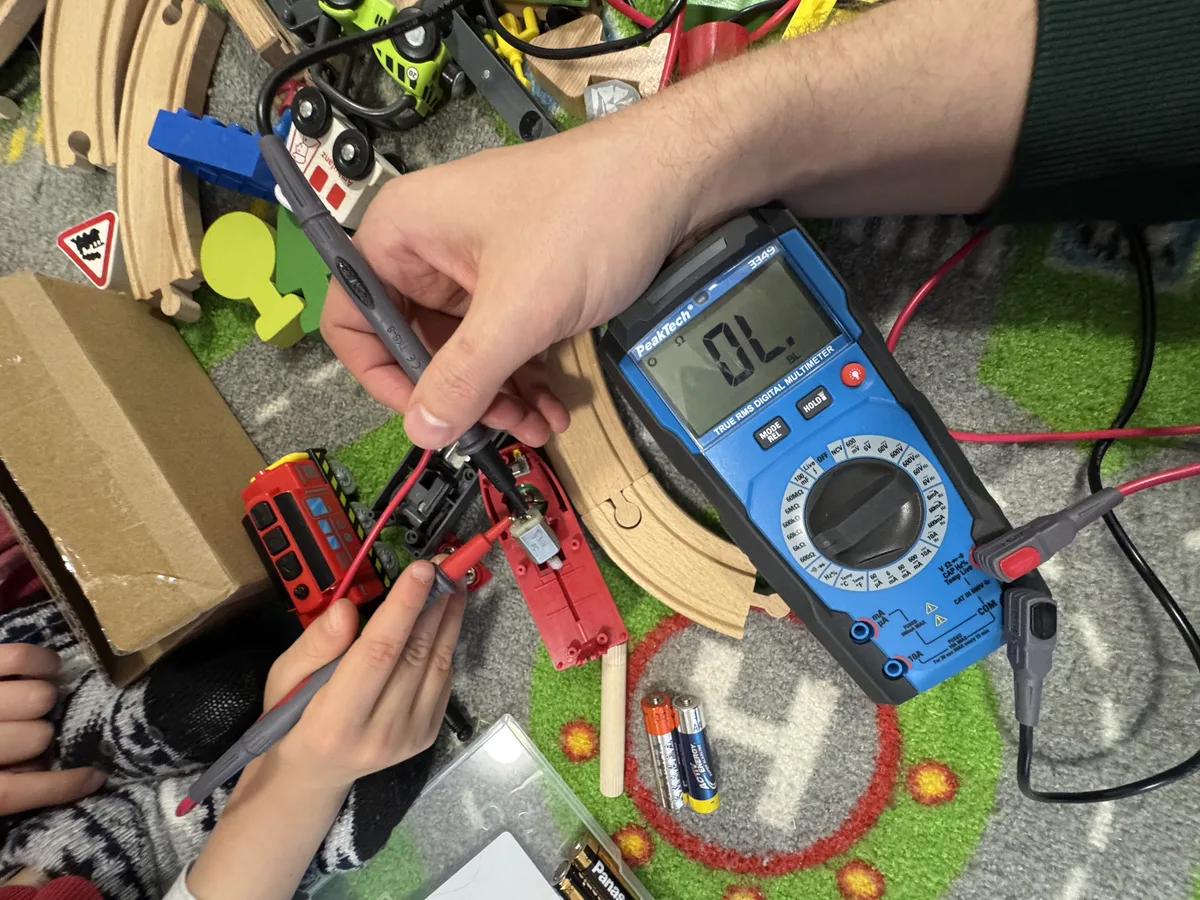 Valentin și Paul măsoară motorul din trenuleț cu multimetrul